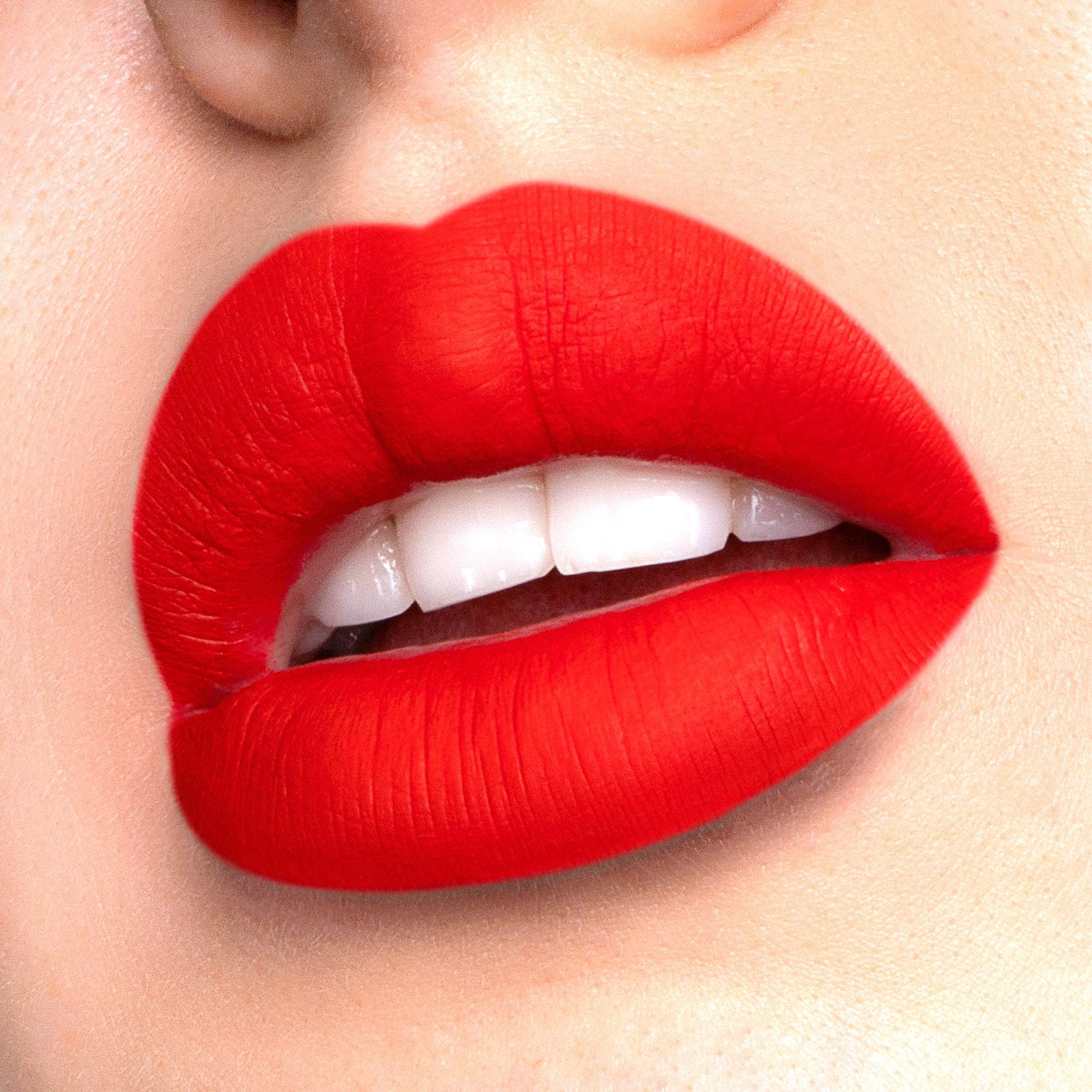 Romance a bright red liquid lipstick swatched on model